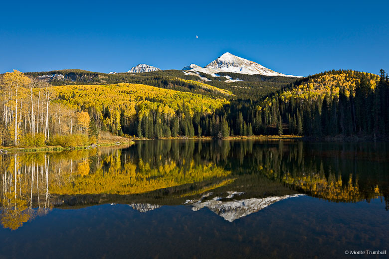 Golden aspens and snow-capped Wilson Peak is reflected in Woods Lake outside of Telluride, Colorado.