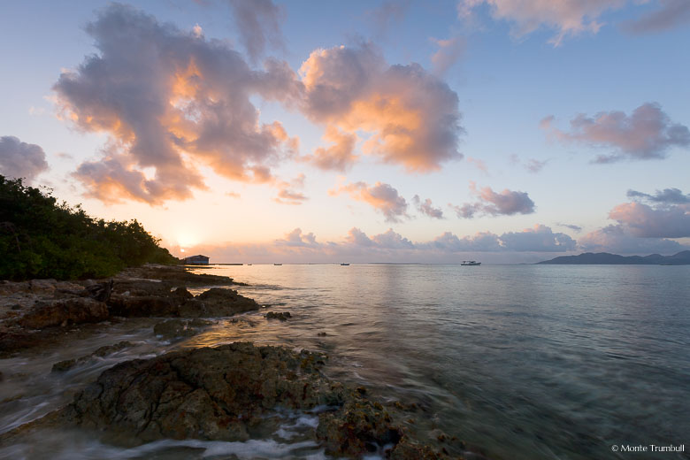 The rising sun lights the clouds and bathes Forest Bay in pastel colors in Anguilla, BWI.